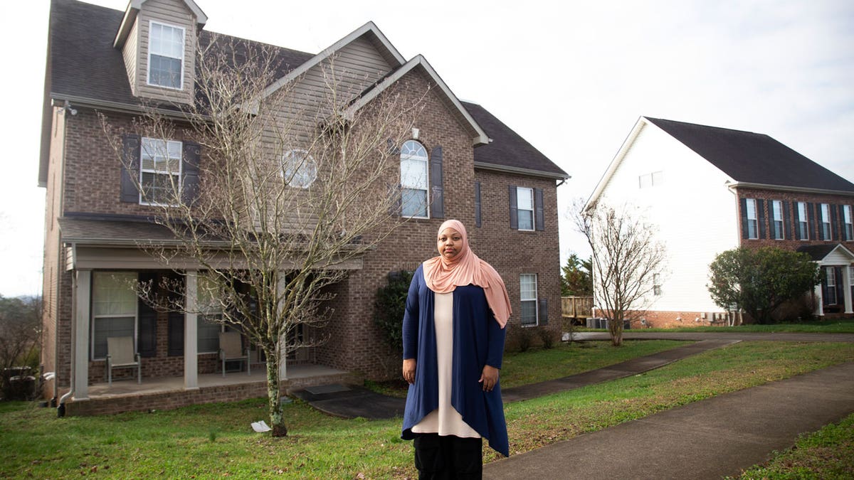 Imani Mfalme poses for a portrait outside her late mother's house