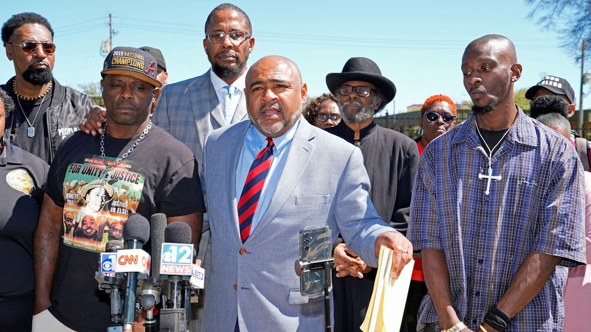 Michael Corey Jenkins, right, and Eddie Terrell Parker, left, stand with their local attorney Trent Walker