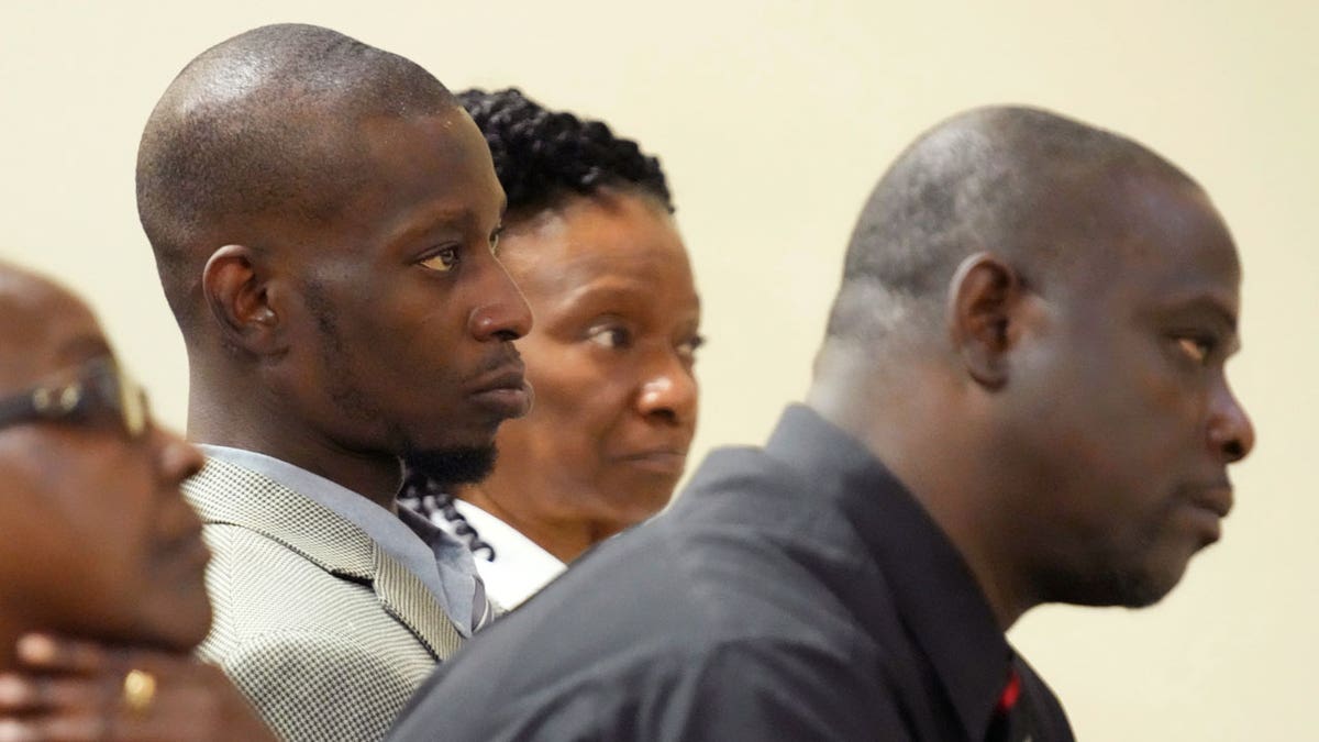 Michael Corey Jenkins, center, and Eddie Terrell Parker, right, listen as one of six former Mississippi law officers pleads guilty to state charges at the Rankin County Circuit Court in Brandon, Mississippi