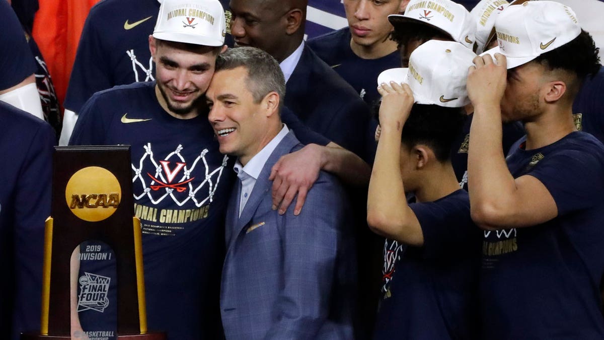 Virginia head coach Tony Bennett, center, celebrates with guard Ty Jerome, left