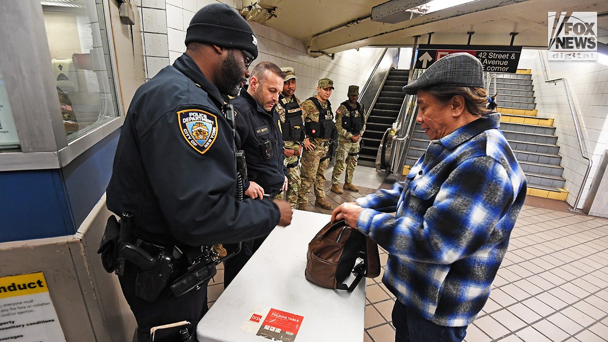 Anggota NYPD dan Penjaga Nasional melakukan pencarian tas acak di sistem kereta bawah tanah Kota New York