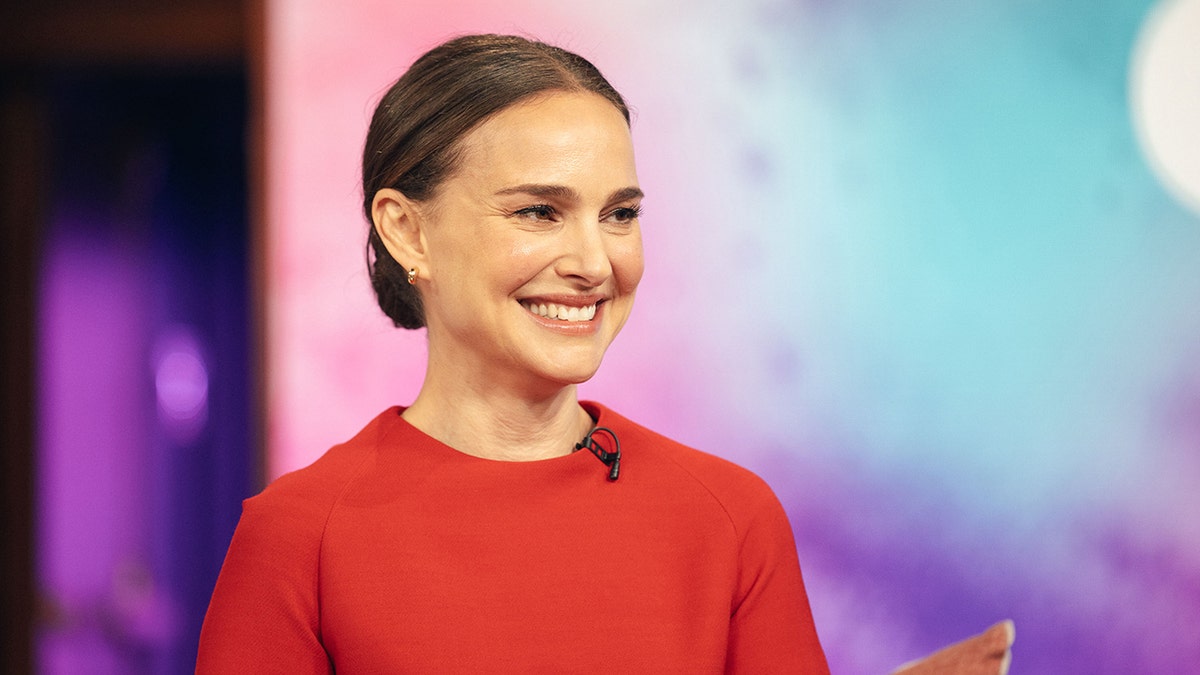 Natalie Portman sitting and smiling