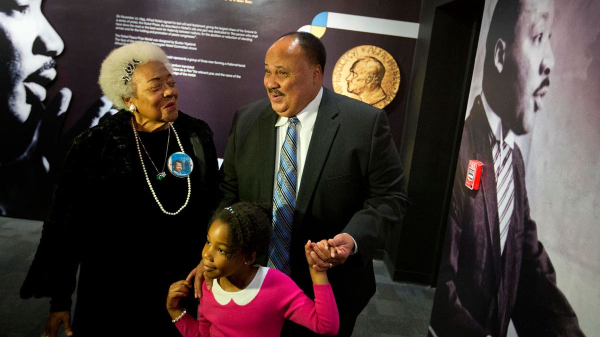 Martin Luther King III, right, walks with his daughter Yolanda, and Naomi King