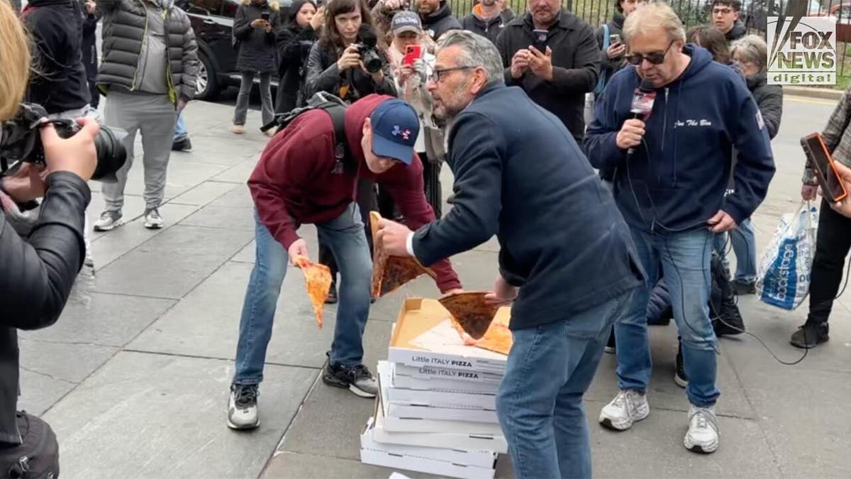Scott LoBaido picking up pizza with another protestor