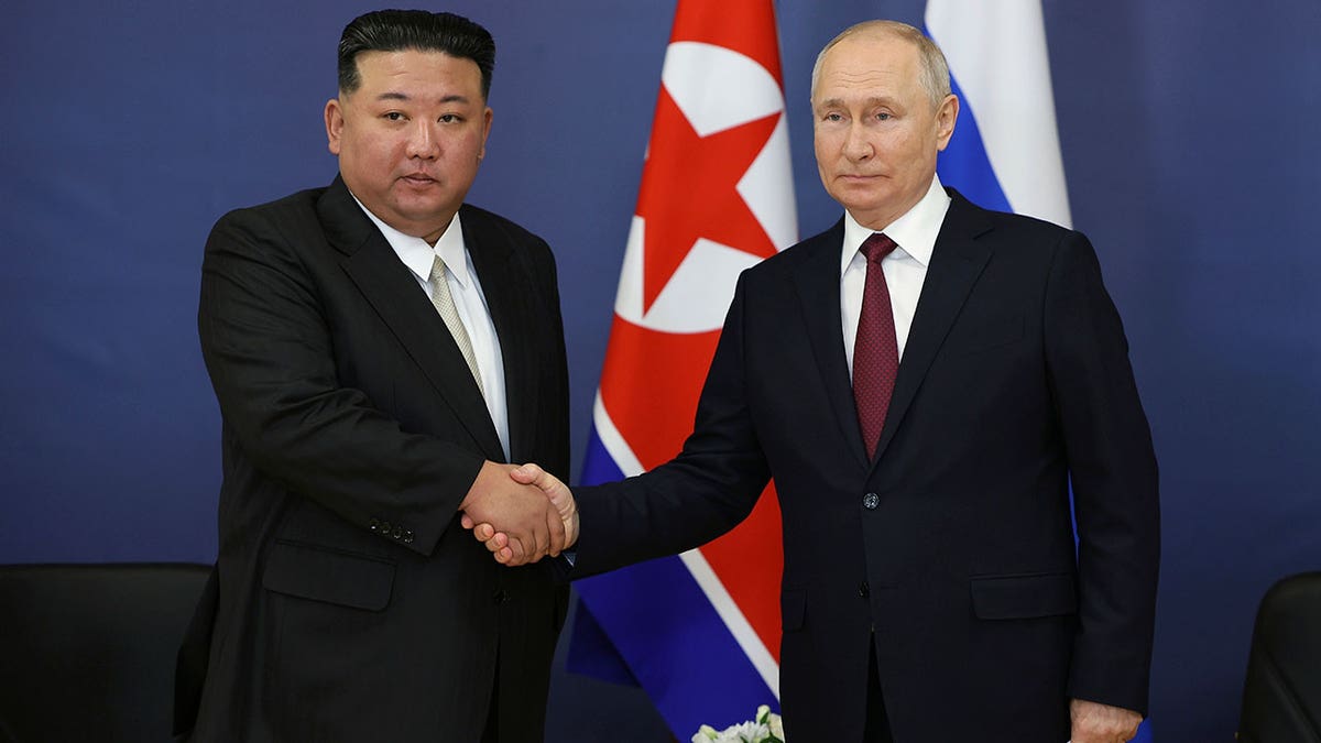 Russian President Vladimir Putin, right, and North Korean leader Kim Jong Un shake hands