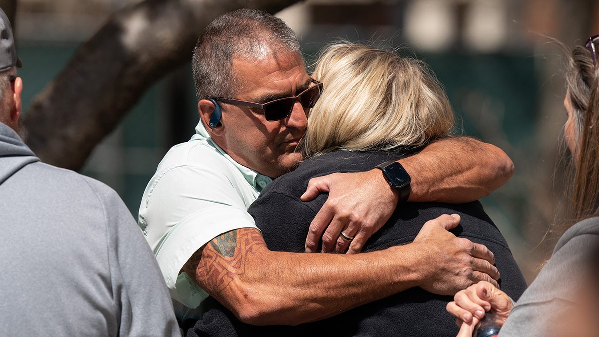 David Flagg, United Cajun Navy, izquierda, abraza a Michelle Strain Whiteid momentos antes de una rueda de prensa para poner al día al público sobre la desaparición de Riley Strain, estudiante de la Universidad de Missouri.