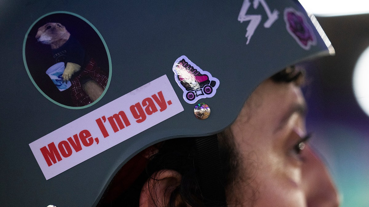 Helmet of roller derby player with sticker reading 'Move, I'm gay.'