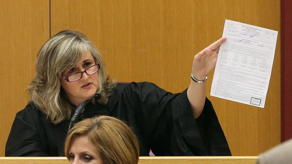 Mobile County Circuit Judge Sarah Stewart holds up a document