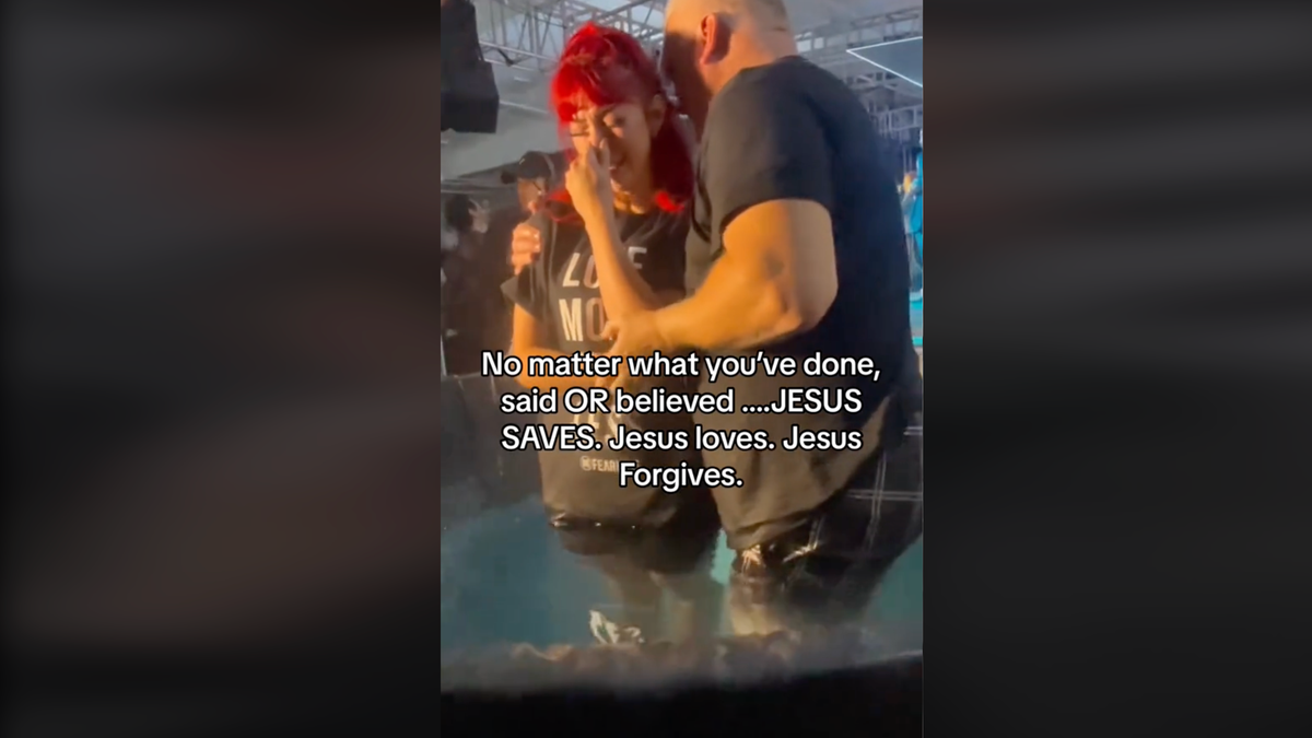 Red headed young woman being baptized