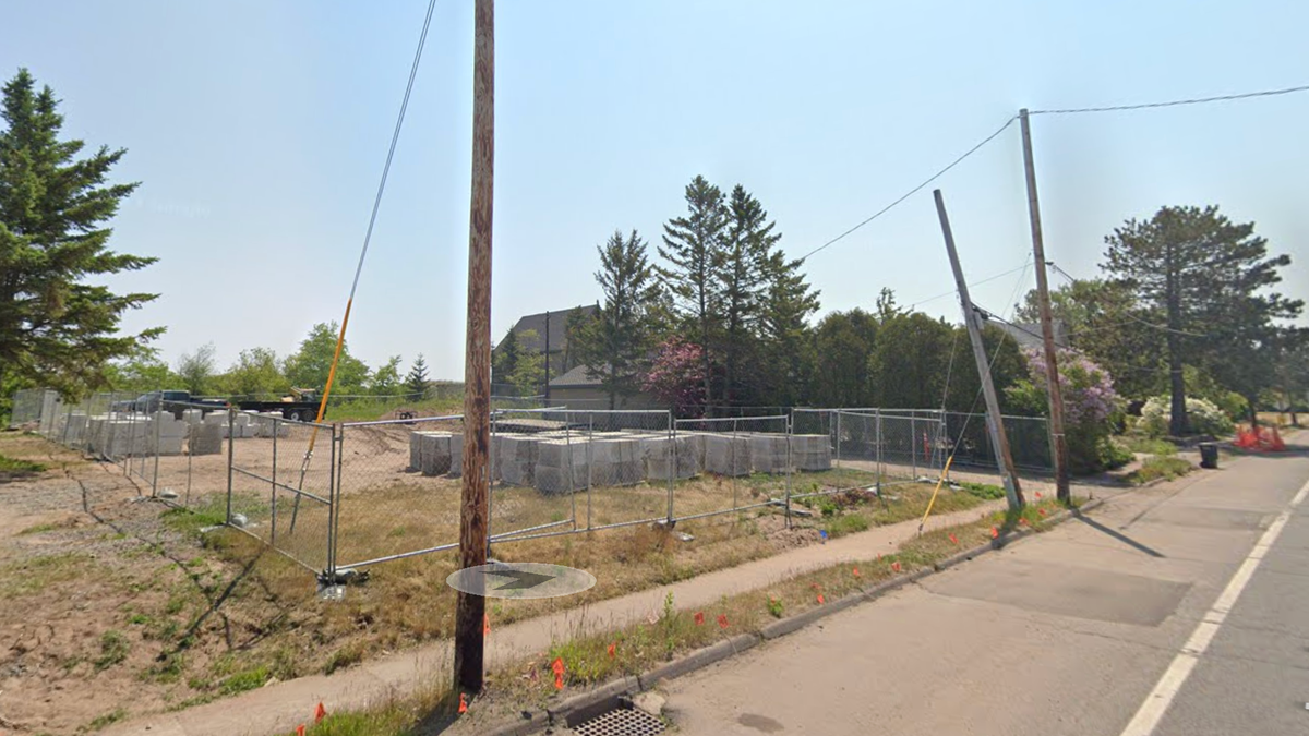 Empty lot with fence around it in Park Point neighborhood.
