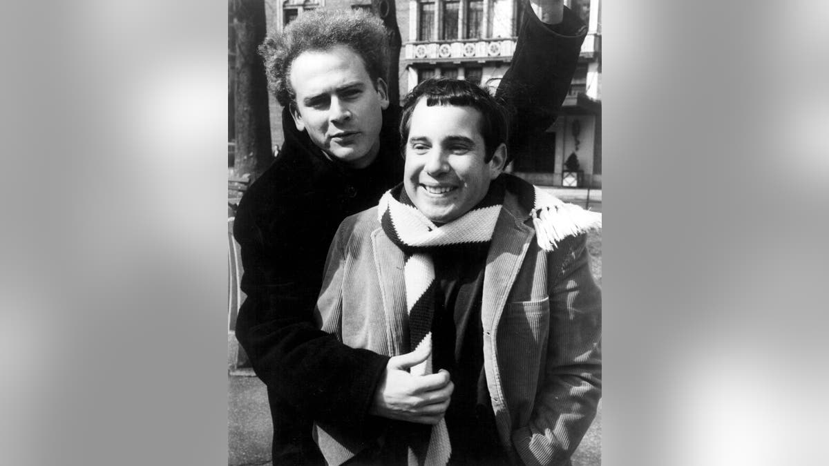 Art Garfunkel with his arm around Paul Simon