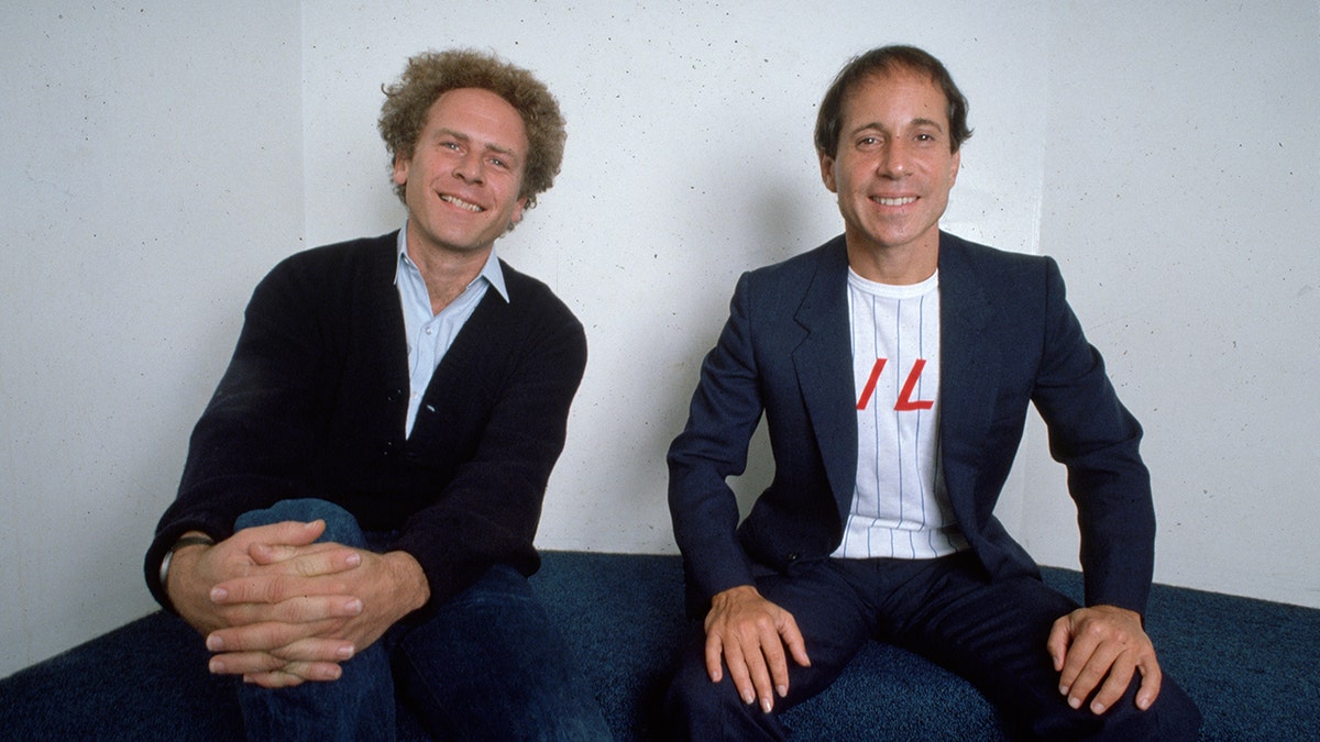 Art Garfunkel and Paul Simon sitting and smiling together