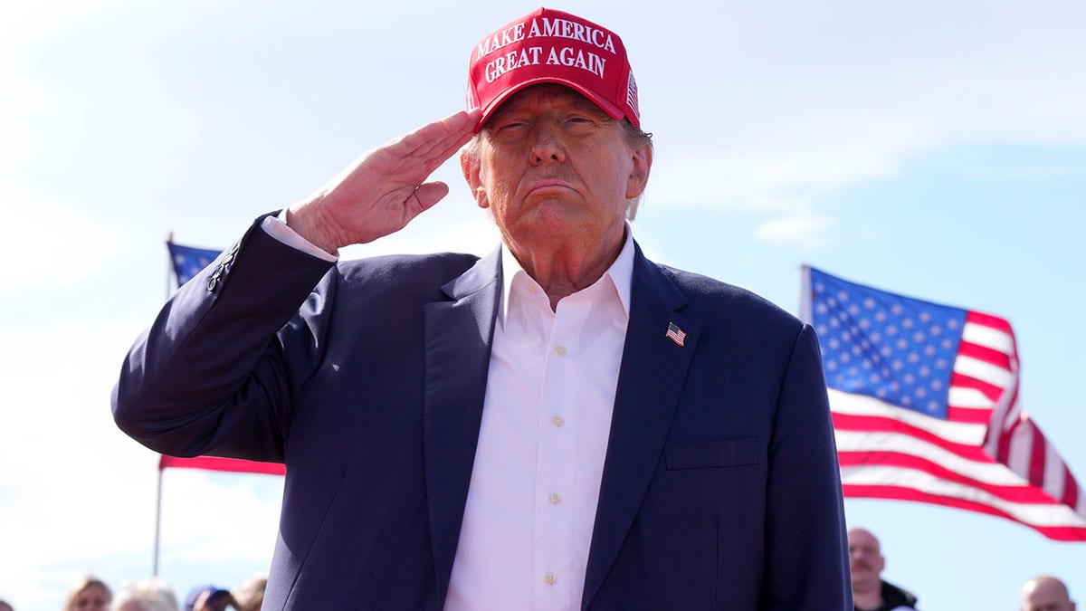 Donald Trump successful reddish MAGA chapeau saluting
