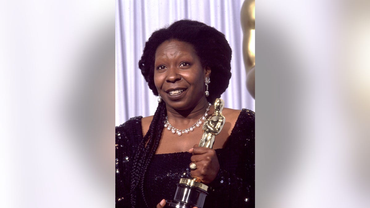 Whoopi Goldberg holding her Oscar backstage