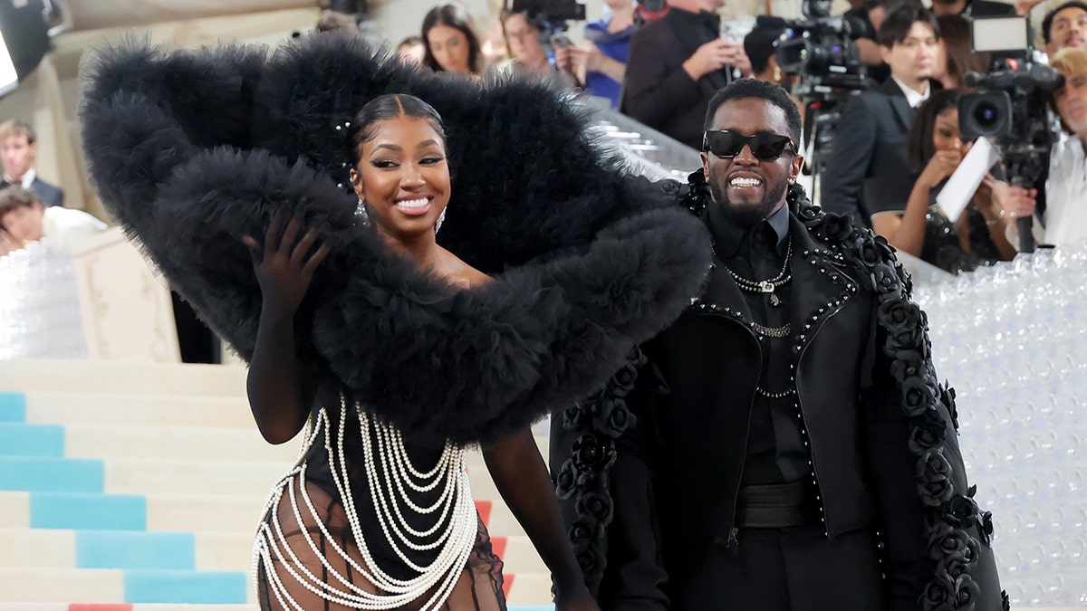 Yung Miami in giant collar posing with Sean "Diddy" Combs at 2023 Met Gala