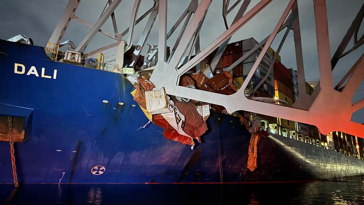 cargo ship under mangled steel from bridge