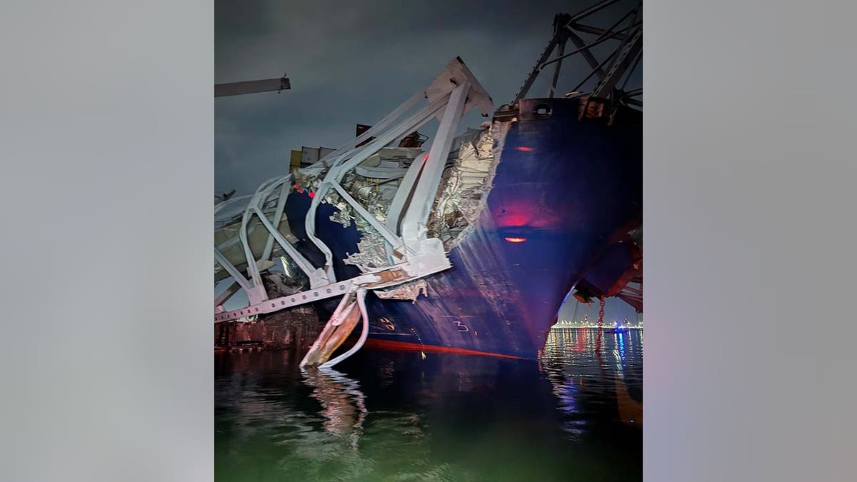 cargo ship under mangled steel from bridge