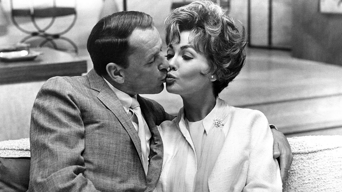 Frank Sinatra and Barbara Rush share a kiss on screen