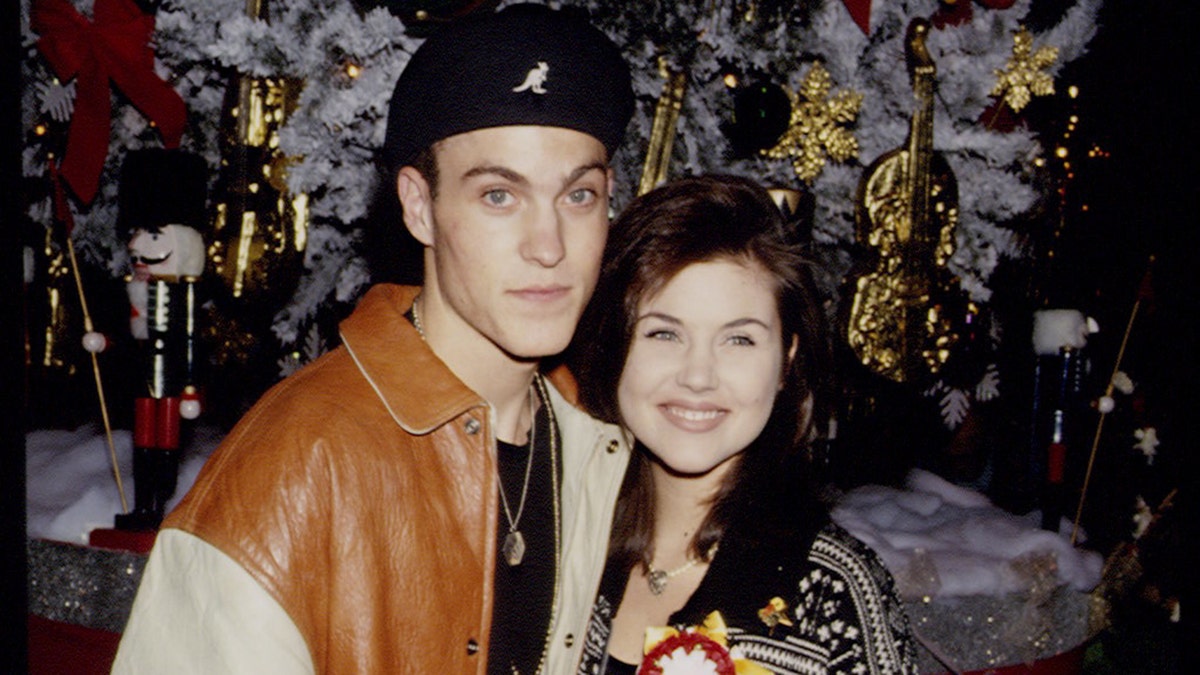 Brian Austin Green and Tiffani Thiessen hugging and smiling