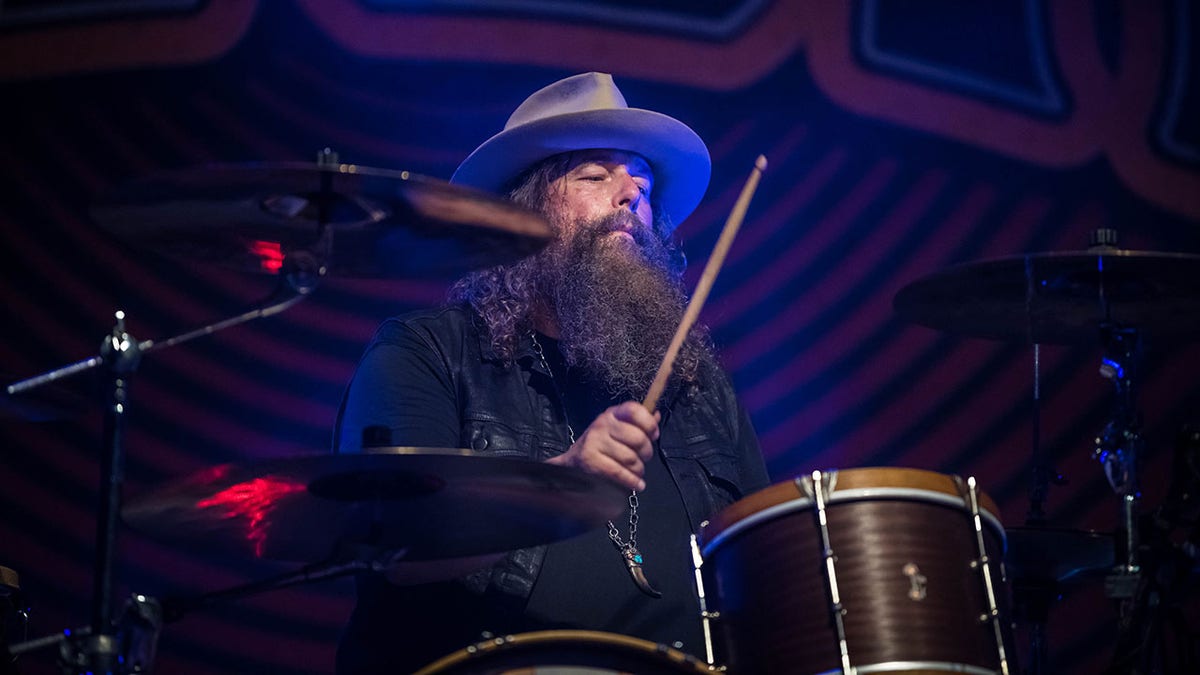 Brit Turner in a wide brimmed hat plays the drums with Blackberry Smoke