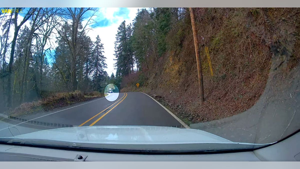 Car on Oregon window road towards trooper