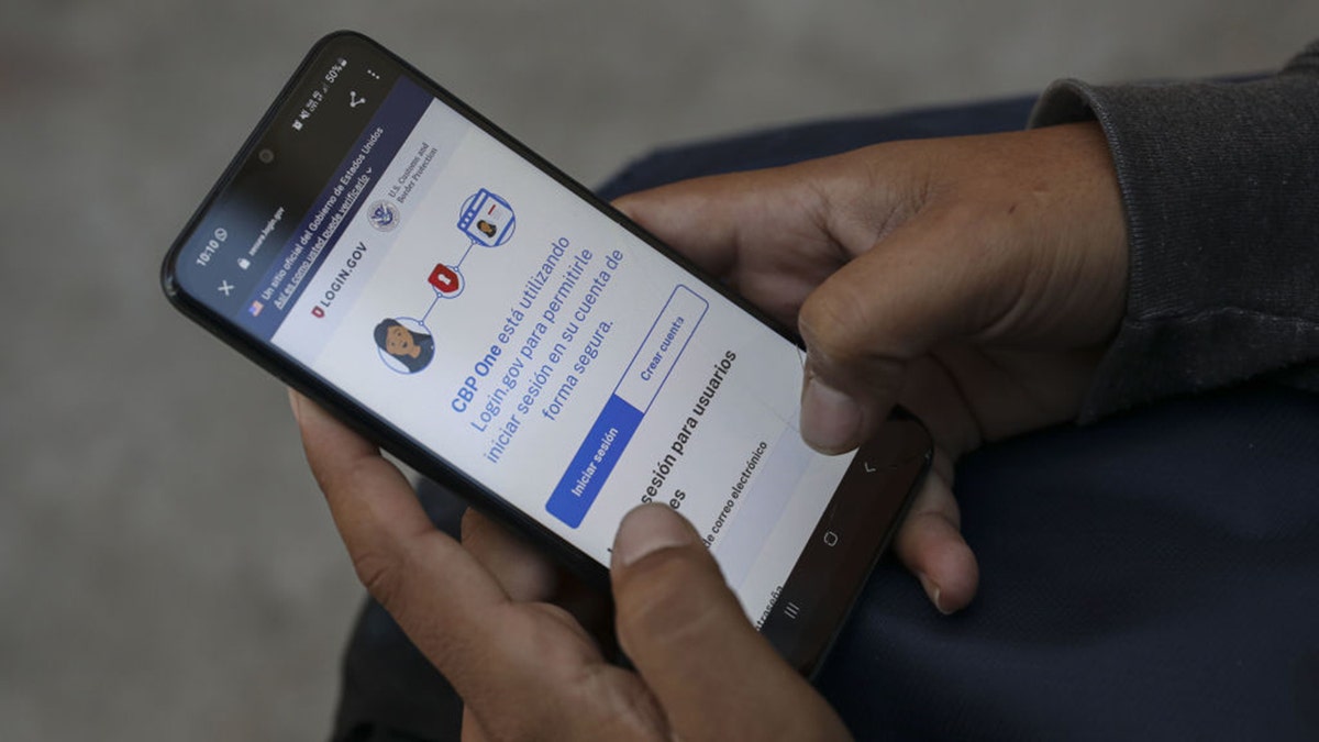 A migrant uses the CBP One application in Tijuana, Mexico.