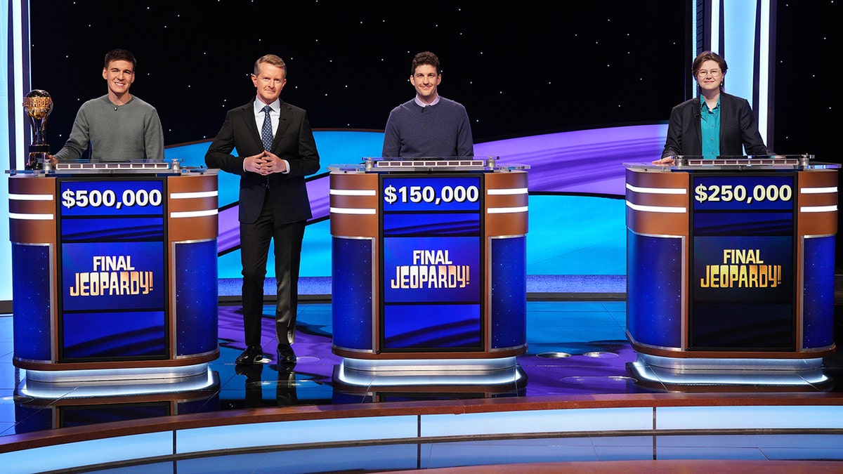 Ken Jennings and three contestants posing for a photo after Final Jeopardy!