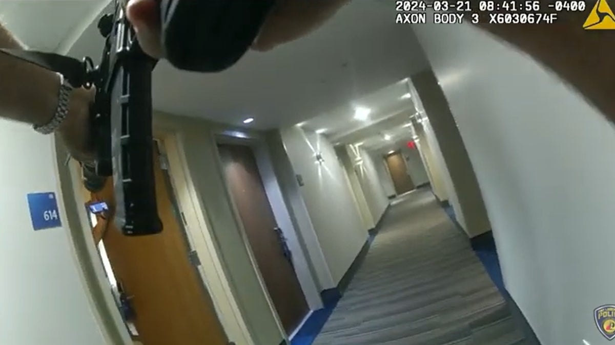 Bodycam from the injured officer shows the suspect (in slow motion) opening the hotel room door.