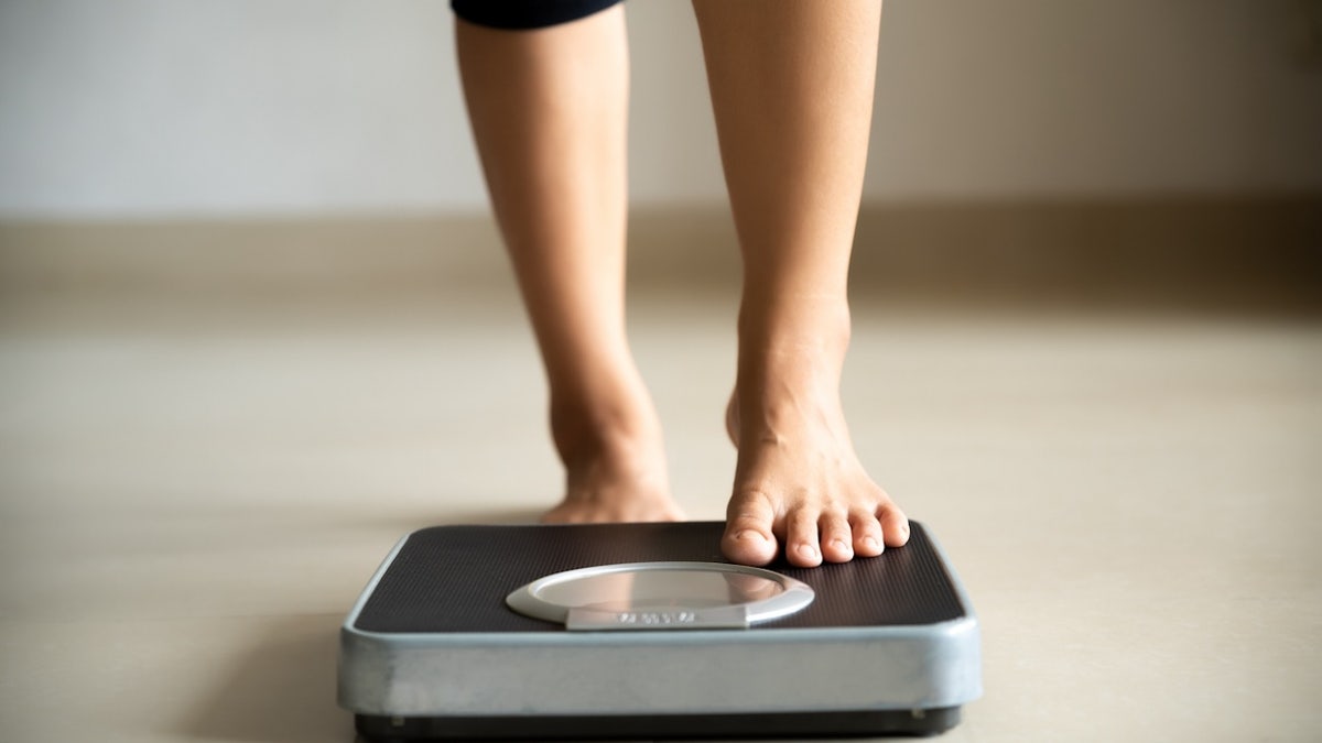 Girl stepping on scale