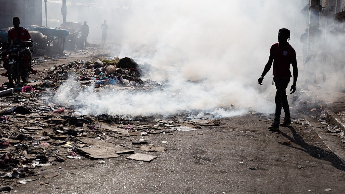 Garbage burns near dead bodies in Haiti