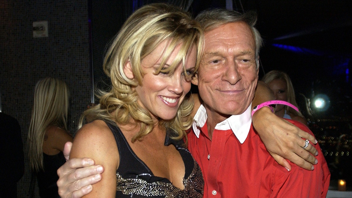 Jenny McCarthy and Hugh Hefner posing for a photo.