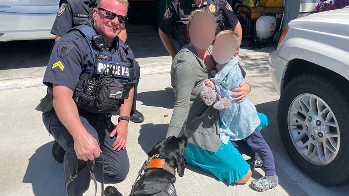 K-9 Midnight and Clark pose with the boy and his mom