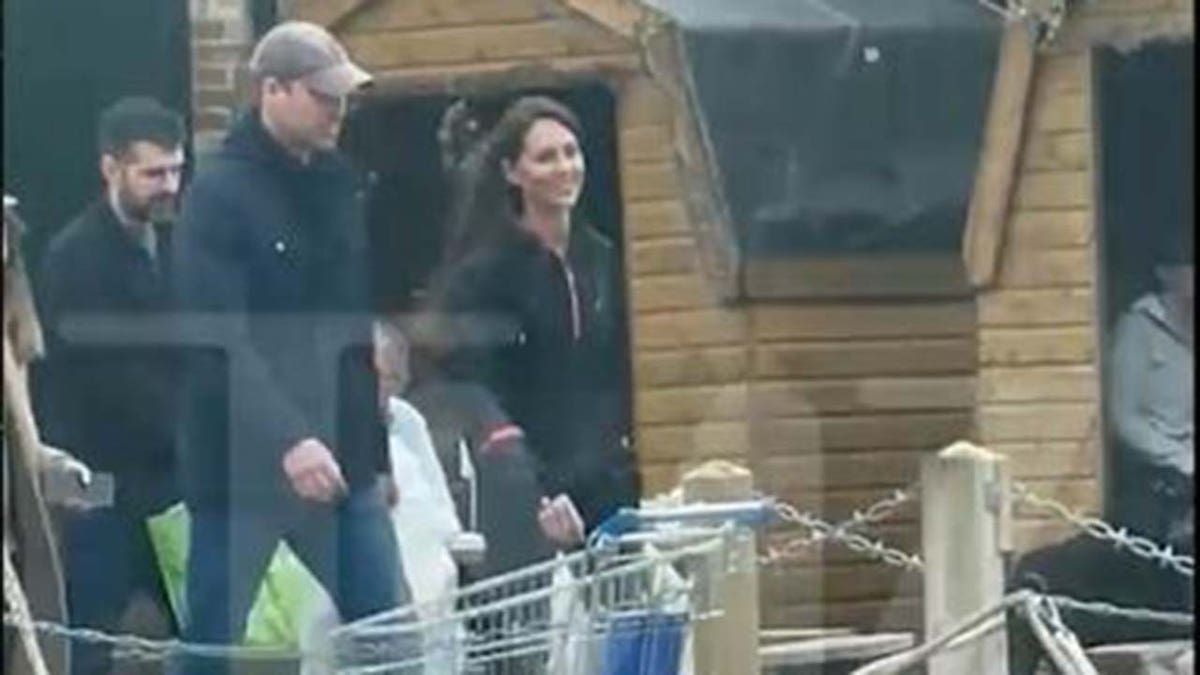 Princesa Kate Middleton sorri enquanto caminha com o Príncipe William perto do Castelo de Windsor