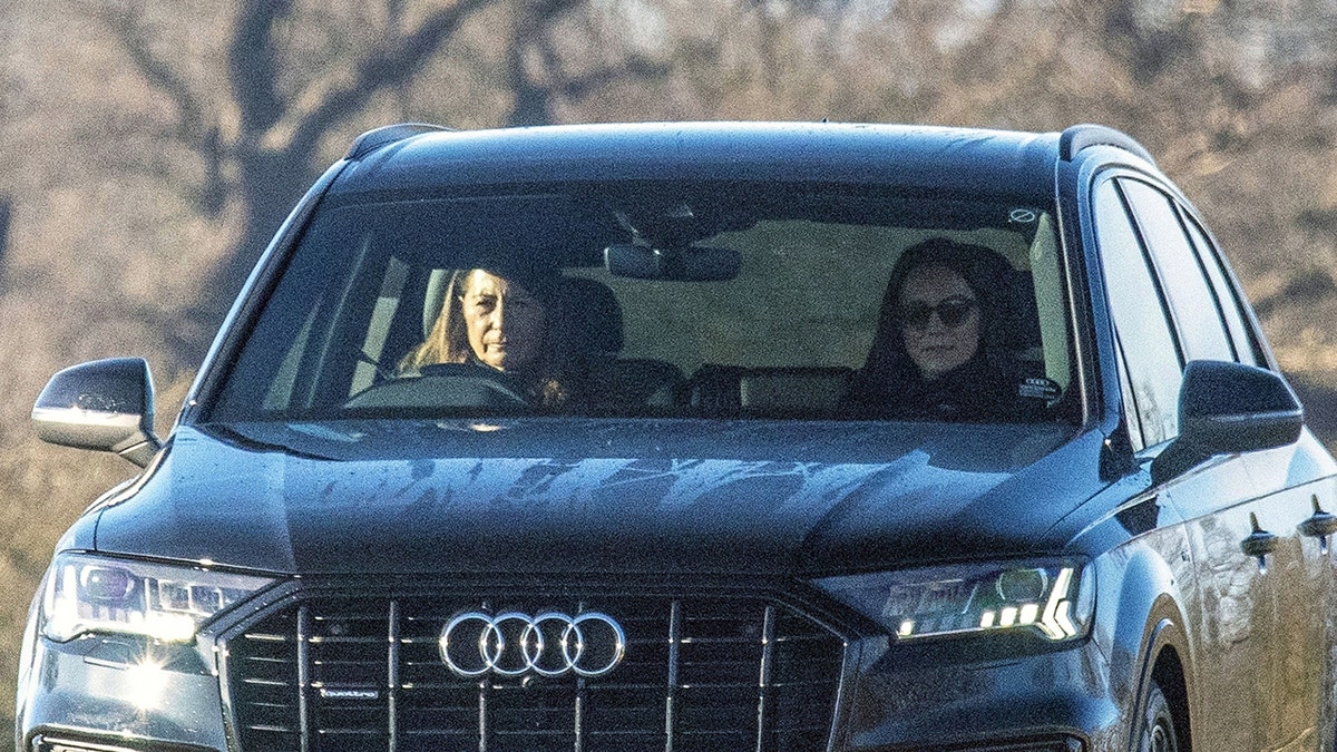 Kate Middleton rides in the passenger seat of a car driven by her mother Carole