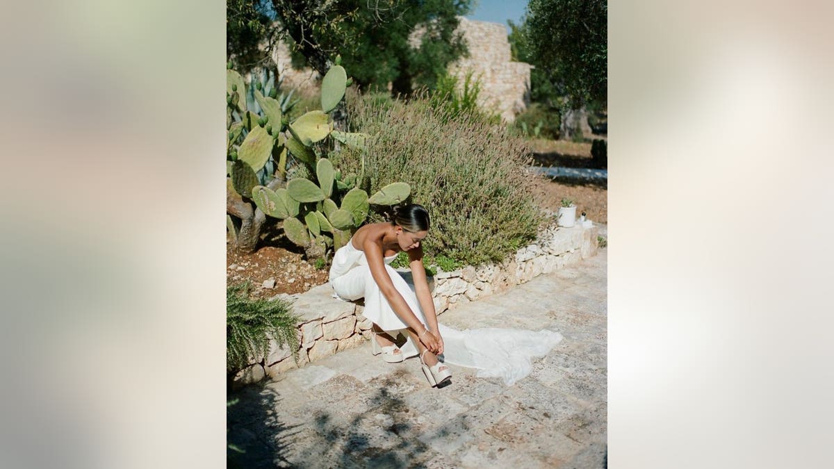 Bride fixing her shoe