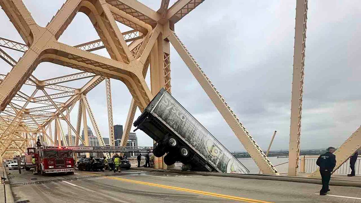 semitruck that is dangling off bridge