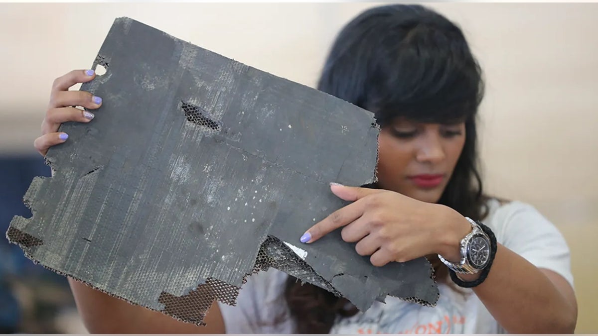 Grace Nathan, whose mother was on the ill-fated Malaysia Airlines Flight 370, shows a serial number on a piece of debris found in Madagascar that is "most likely" from MH370 at the Ministry of Transport in Putrajaya, Malaysia, Friday, Nov. 30, 2018.