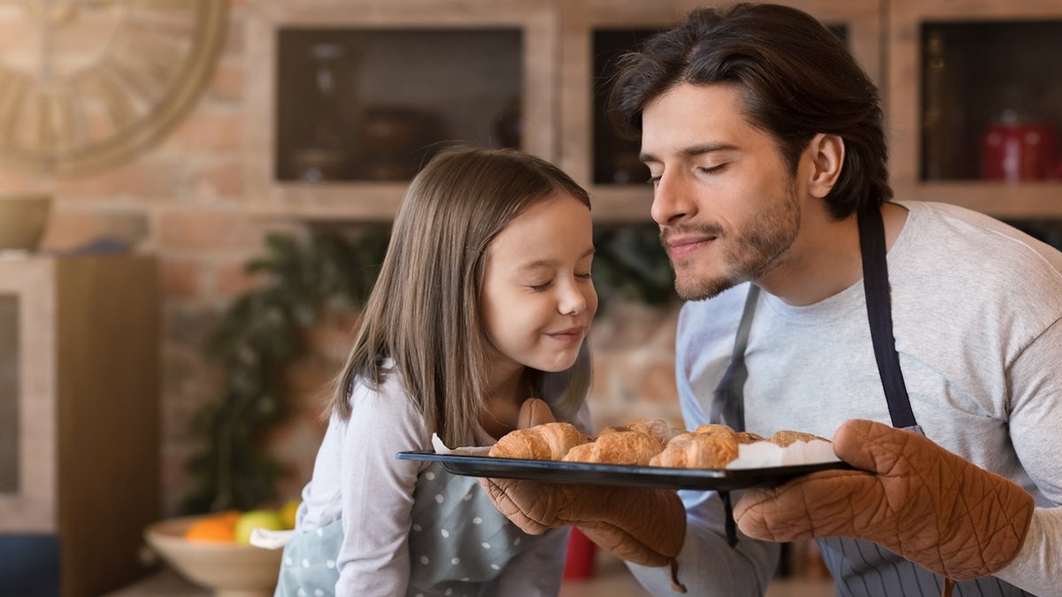 Man and girl smelling croissants