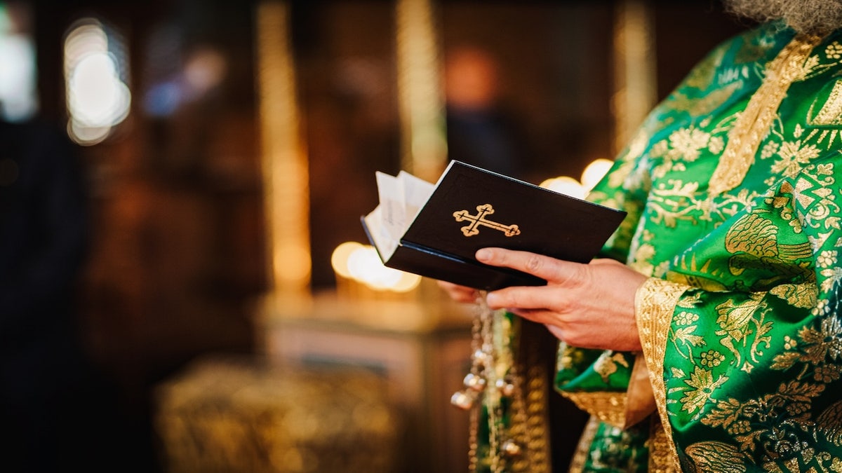 Priest holding a bible