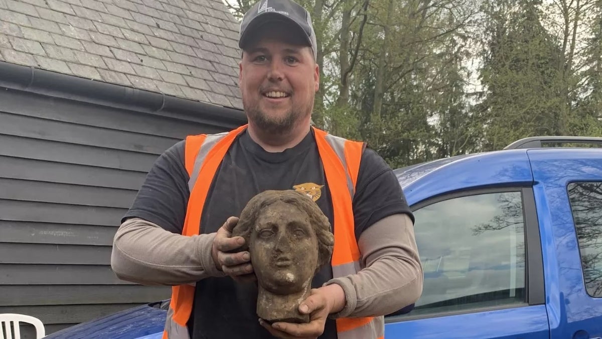 Digger Greg Crawley holds the head of a Roman sculpture that he unearthed during a construction project.