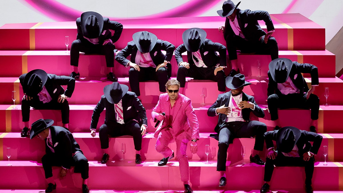 Ryan Gosling performing at the Academy Awards in a pink suit.