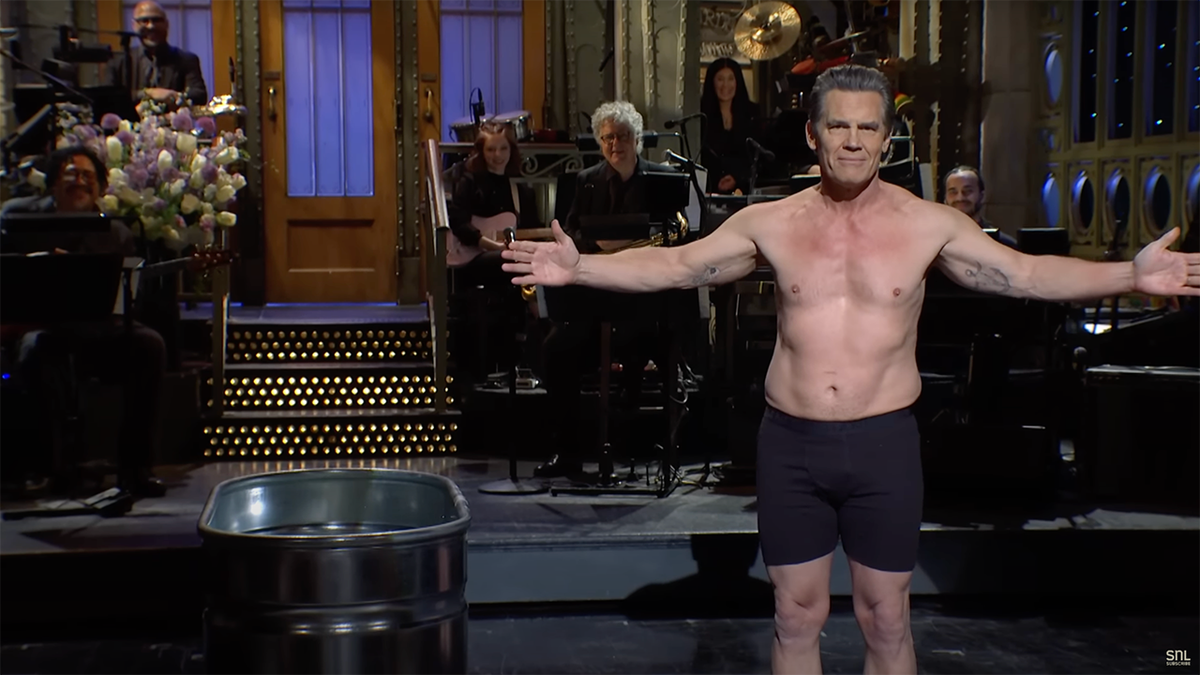 Josh Brolin está no palco do 'SNL' durante seu monólogo de abertura vestindo boxers e abrindo os braços