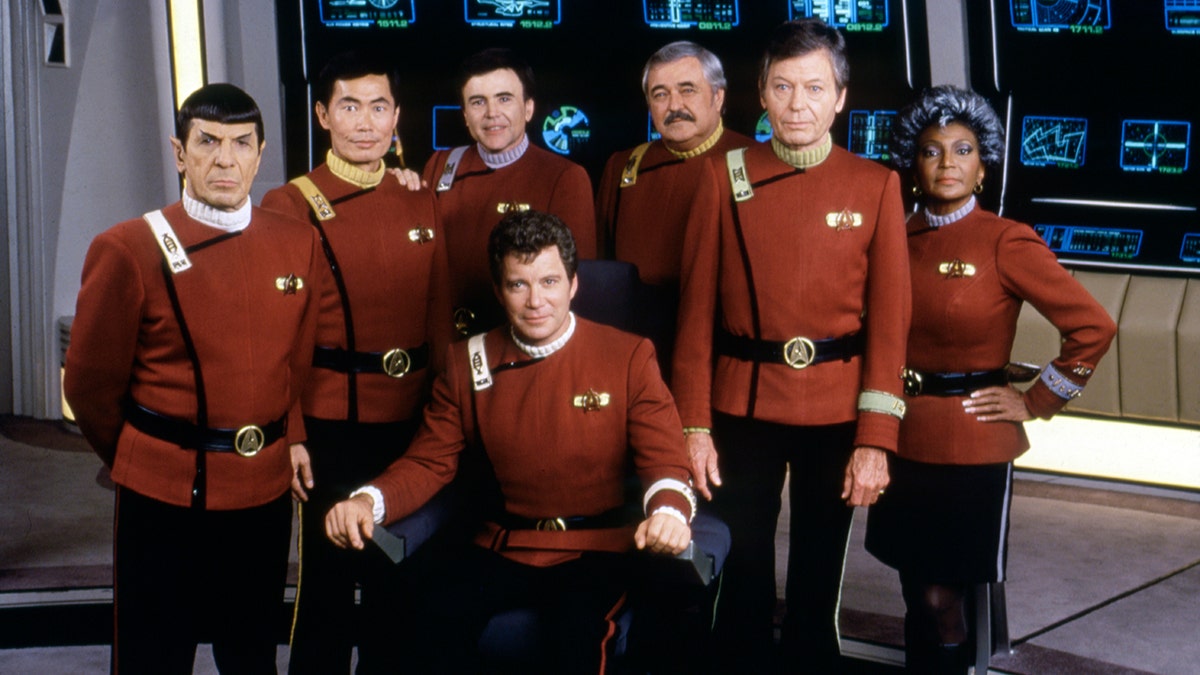 Leonard Nimoy, George Takei, Walter Koenig, DeForest Kelley, Nichelle Nichols, and William Shatner all in red suits on the set of "Star Trek V: The Final Frontier"