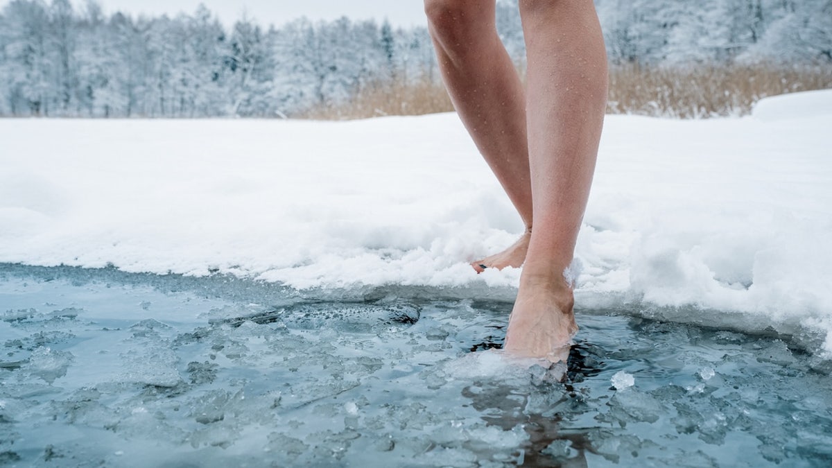 Woman stepping into ice bath