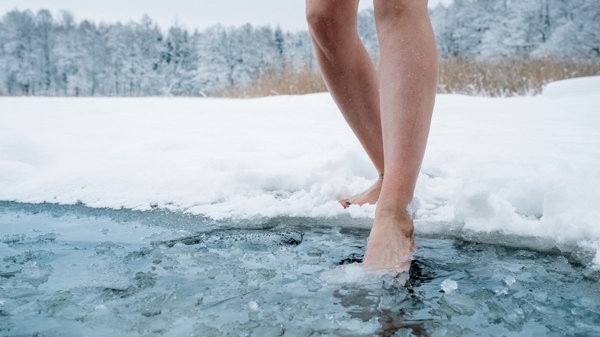 Woman stepping into ice bath