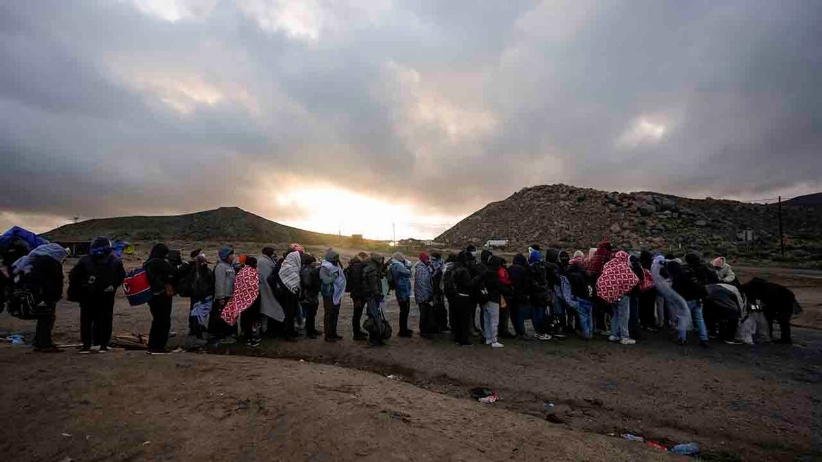 migrants line up at campsite