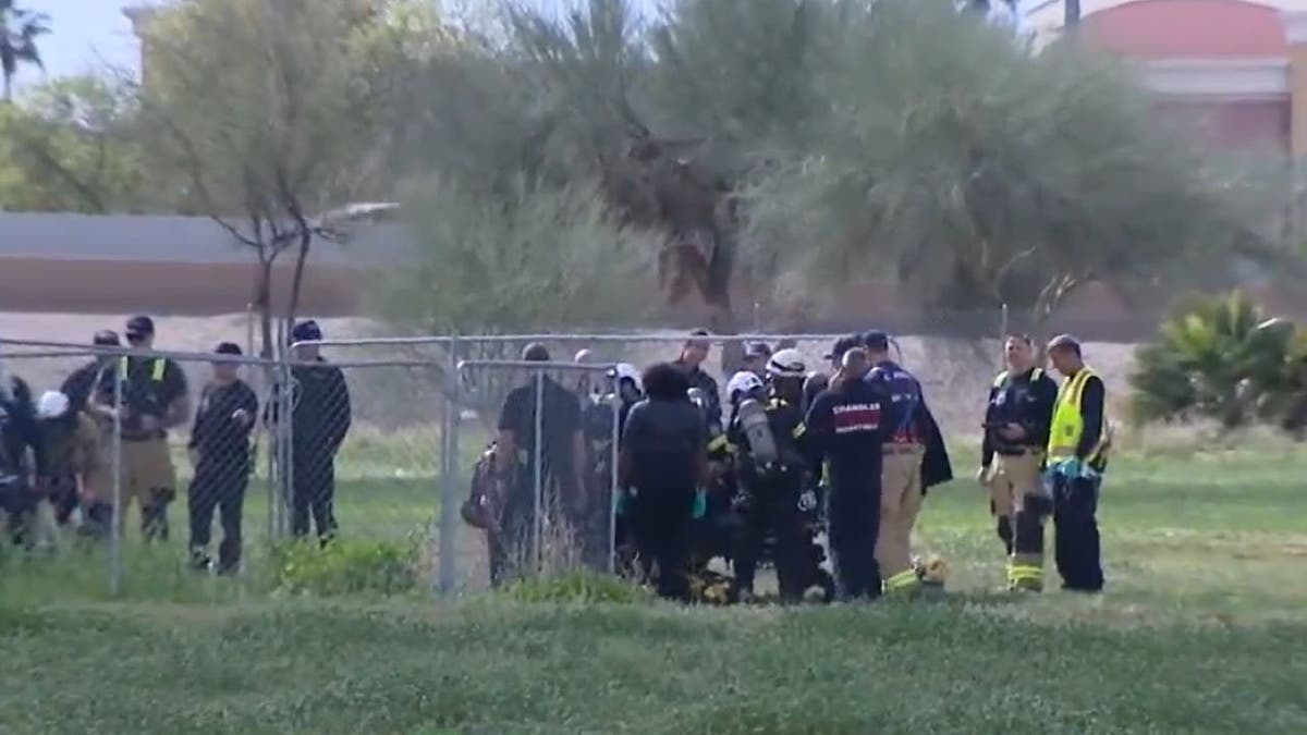 Wide shot of firefighters working near well