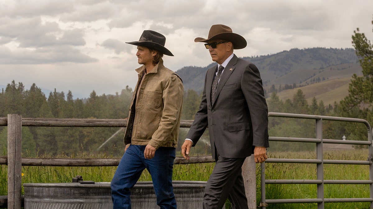 Kayce Dutton (Luke Grims) and John Dutton (Kevin Costner) walk in stride in a shot from "Yellowstone"