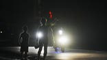 A woman and a boy attempt to hitch a ride during a scheduled power outage in Bauta, Cuba, Monday, March 18, 2024 The island is facing an energy crisis, with waves of blackouts worsening in recent weeks.