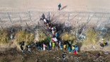EL PASO, TEXAS - MARCH 13: In an aerial view, immigrants pass through coils of razor wire while crossing the U.S.-Mexico border on March 13, 2024 in El Paso, Texas. The wire was placed by the troops as part of Texas Governor Greg Abbott's "Operation Lone Star" to deter migrants from crossing into Texas. The vast majority of immigrants, however, manage to pass through it, and are then permitted to turn themselves in to U.S. Border Patrol agents, usually to request asylum. The border between the two nations stretches nearly 2,000 miles, from the Gulf of Mexico to the Pacific Ocean and is marked by fences, deserts, mountains and the Rio Grande, which runs the entire length of Texas. The politics and controversies surrounding border and immigration issues have become dominant themes in the U.S. presidential election campaign. (Photo by John Moore/Getty Images)